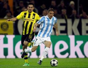 Borussia Dortmund's Guendogan runs for the ball with Malaga's Joaquin during Champions League quarter-final second leg soccer match in Dortmund
